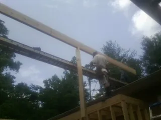 Carpenter setting a ridge beam over a new addition frame — Ice Dam Removal by Roofing Brothers in Dacula