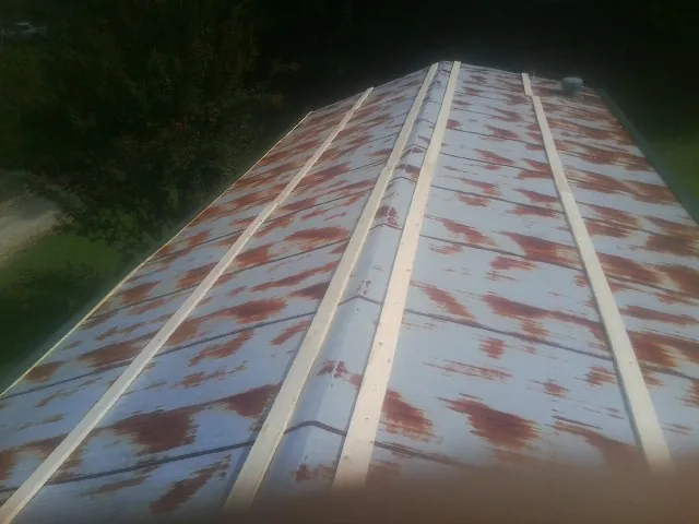 Rusted metal roof panels with new wood purlins before replacement — Storm Damage Roof Repair in Dacula by Roofing Brothers