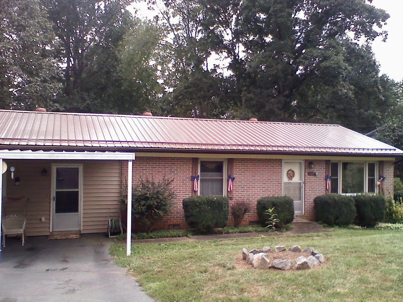 Bronze metal roof and carport on a brick ranch home — Roof Repair work by our crew in Dacula