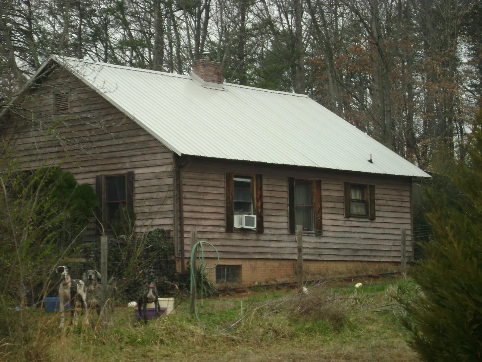 White metal roof on an old wood sided farmhouse, from a Asphalt Shingle Roof Repair job in Dacula